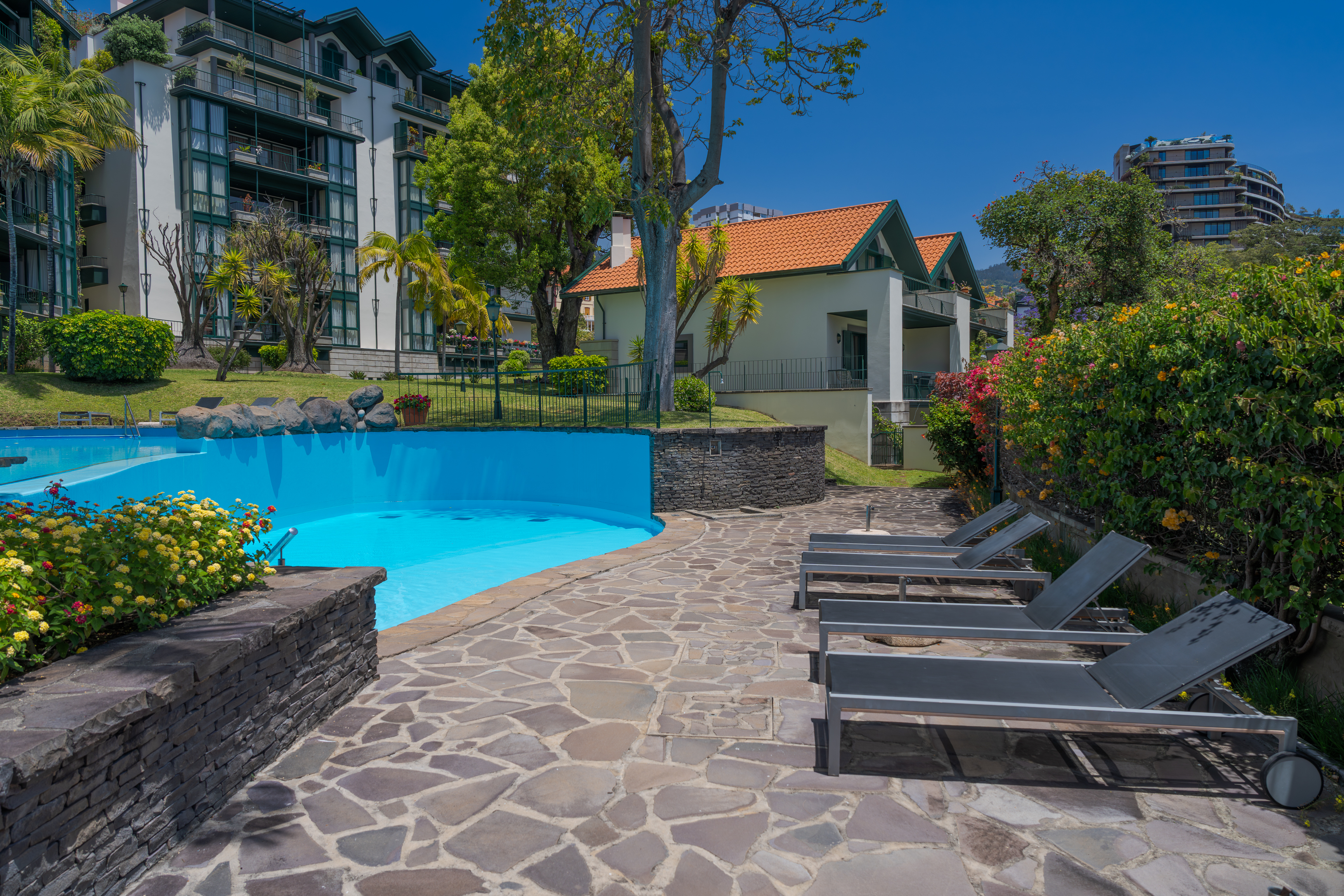 Piscina com espreguiçadeiras e jardins