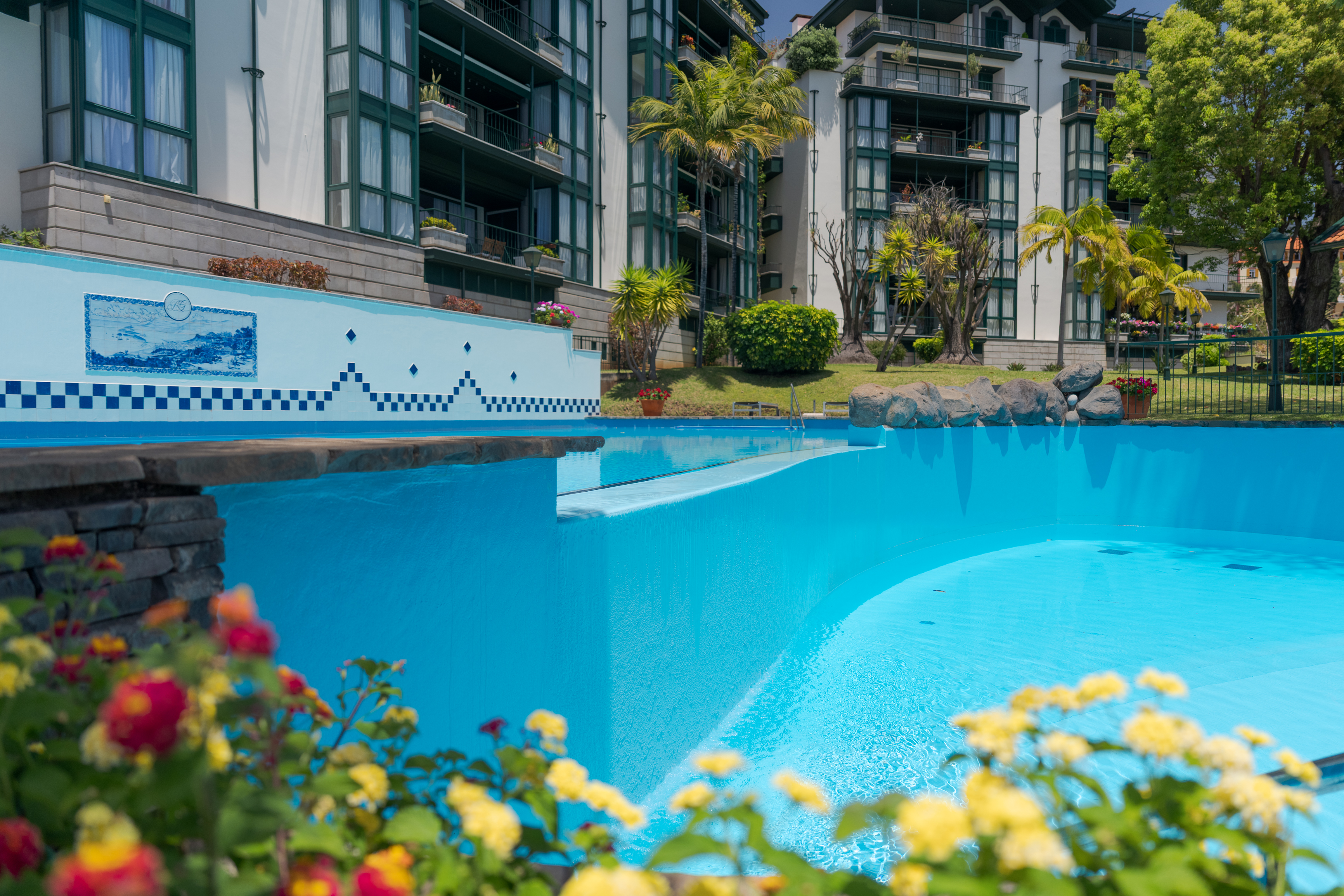 Piscina rodeada de flores e jardins